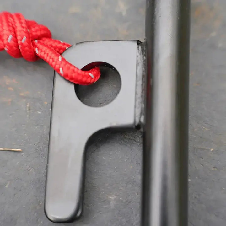 Close-up of black tent peg with red rope loop, part of outdoor camping canopy accessories from HIDE WALKER.