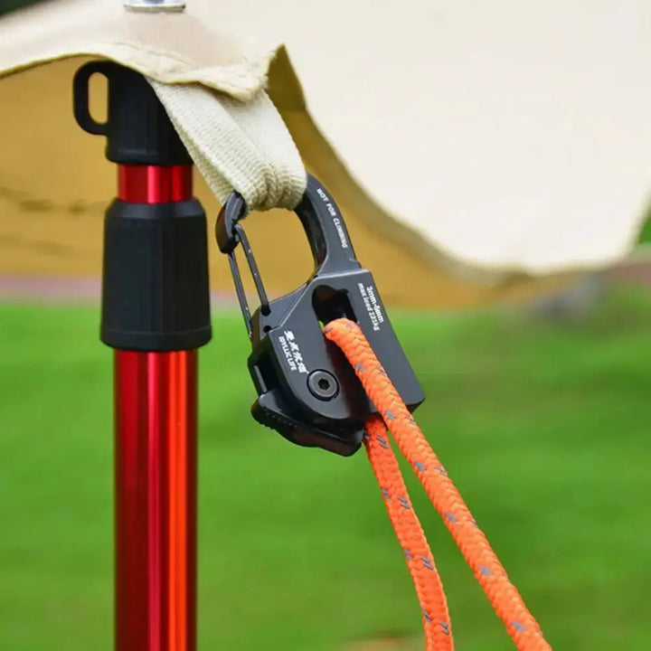 "Aluminum camping rope tensioner with orange cord on tent pole outdoors"