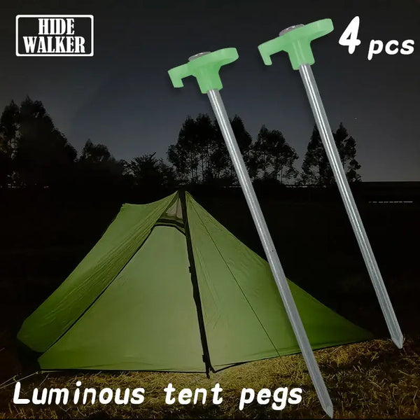 "Pack of 4 luminous tent pegs with green handles beside a tent at night, ideal for camping and outdoor use, HIDE WALKER brand"