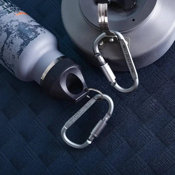 Durable D-shape mini carabiner set attached to a water bottle and kettle, ideal for camping, hiking, and mountaineering accessories.